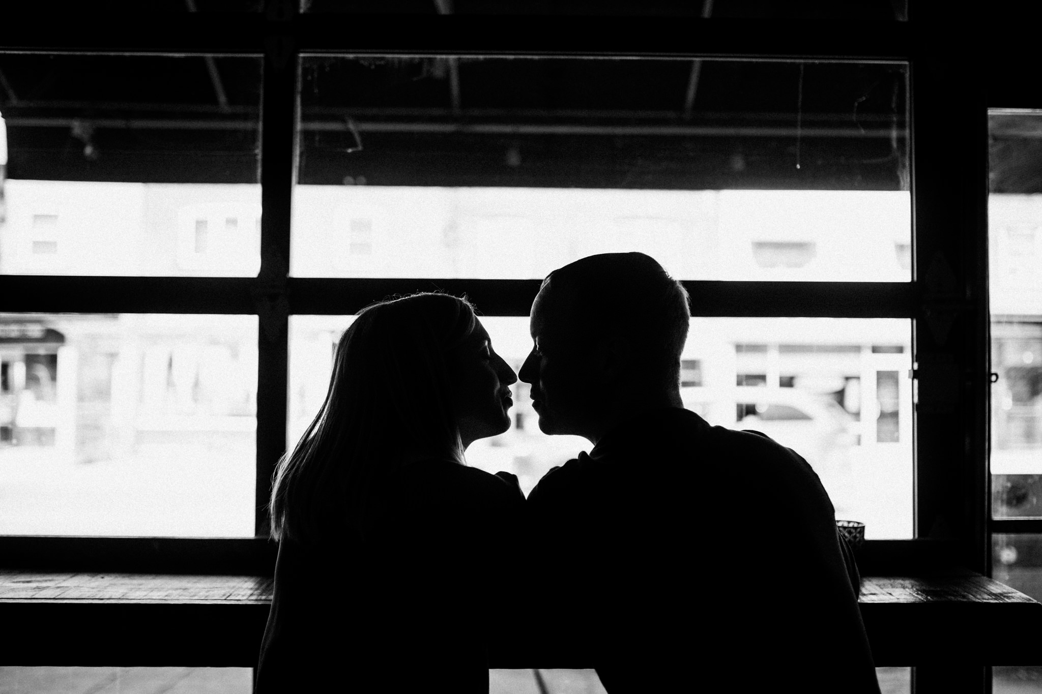 silhouette of couple kissing in a store front