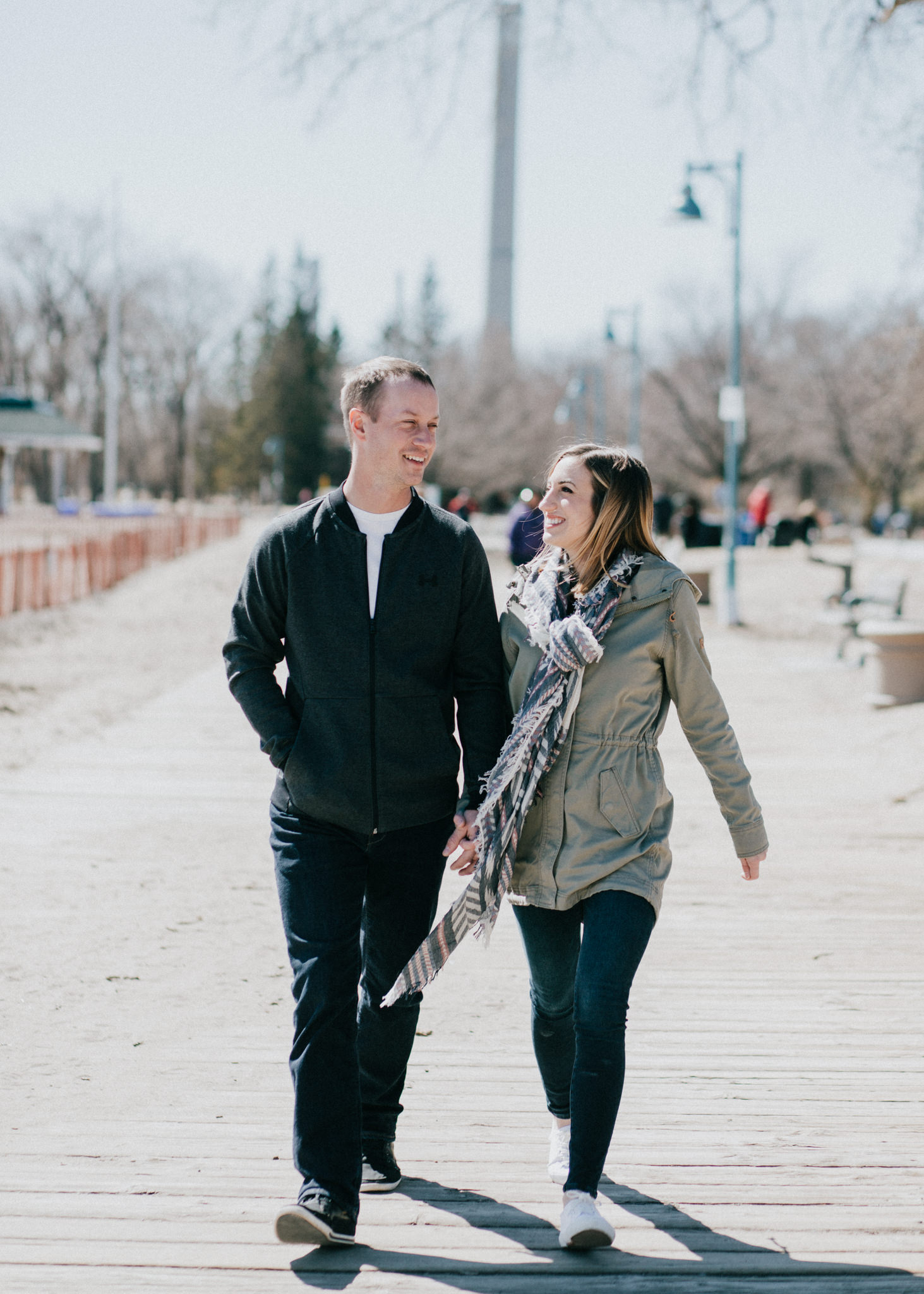 couple walking on the boardwalk on a spring day at woodbine beach