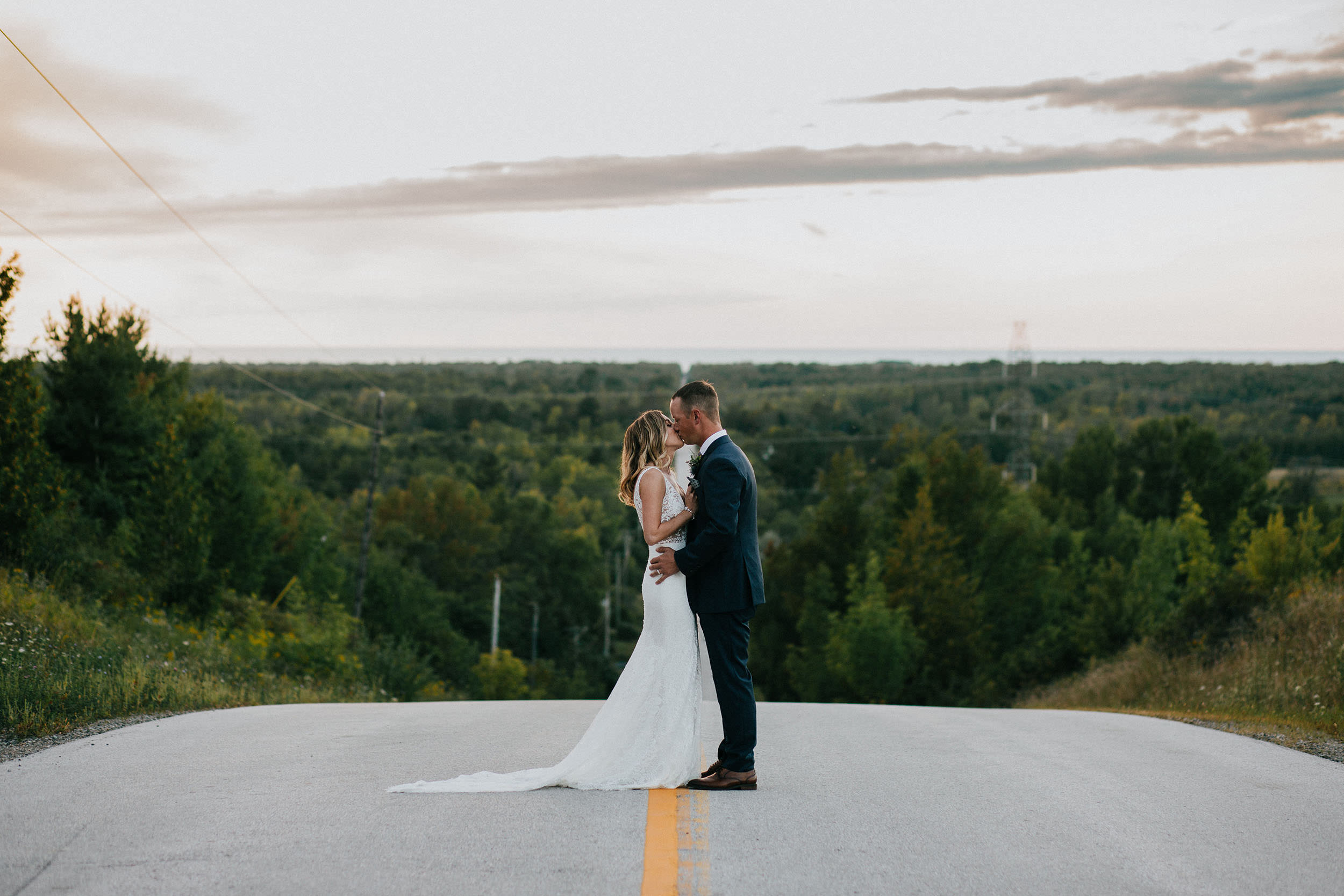 bride and groom standing on a road