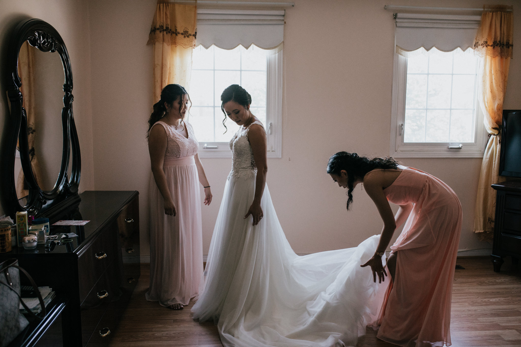 bridesmaid help bride fluff her dress